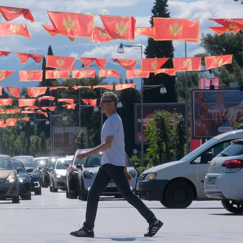 A man walks on a street decorated with national flags in Montenegro's capital Podgorica, Monday, May 18, 2026. (AP Photo/Risto Bozovic)