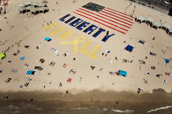An installation with the U.S. flag and the message "liberty for all," which was created by relatives and supporters of Israelis held captive in the Gaza Strip, calls for their release and urges a ceasefire on the beach in Tel Aviv, Israel, on Friday, July 4, 2025. (AP Photo/Oded Balilty)