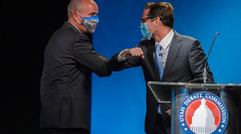 This photo taken Sept. 29, 2020, shows Utah Lt. Gov. Spencer Cox, left, a Republican and Democratic challenger Chris Peterson, rivals to become Utah's next governor, bumping elbows after facing each other in a prime-time debate in Salt Lake City. The two released dual ads calling for "civility." (Trent Nelson/The Salt Lake Tribune, via AP, Pool)