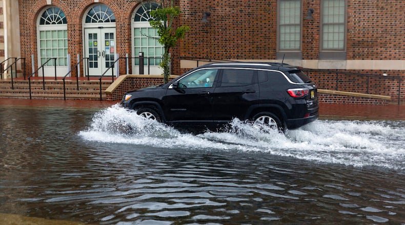A sport utility vehicle moves down a flooded street in Ventnor, N.J., Friday, July 10, 2020. Fast-moving Tropical Storm Fay made landfall in New Jersey on Friday amid heavy, lashing rains that closed beaches and flooded shore town streets. (Kristian Gonyea/The Press of Atlantic City via AP)