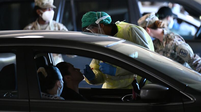 April 22, 2020 Duluth - A medical professional collects a nasal swab from a potential COVID-19 patient at a drive-through COVID-19 testing site for anyone who is experiencing symptoms at the Infinite Energy Center in Duluth on Wednesday, April 22, 2020. A drive-through COVID-19 testing center is open in Gwinnett County for anyone who is experiencing symptoms â with no doctorâs orders necessary. The Gwinnett, Newton and Rockdale County Health Department conducted 800 tests at the event venue, its second large-scale testing event in a week. (Hyosub Shin / Hyosub.Shin@ajc.com)