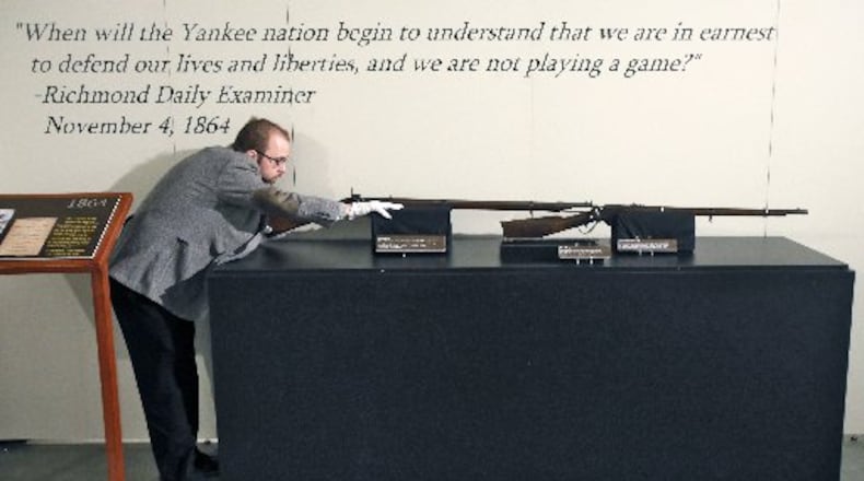 Southern Museum curator Jonathan Scott with rifles on display in the exhibit "1864." BOB ANDRES/ BANDRES@AJC.COM