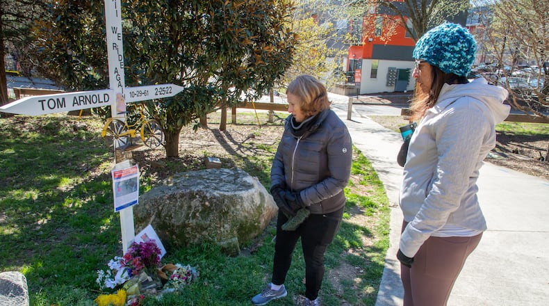 Susan Levy (left) and Amy El-Bassioni look over the memorial for Thomas Arnold near the Beltline on Sunday. Atlanta police have made one arrest in his Feb. 26 killing.