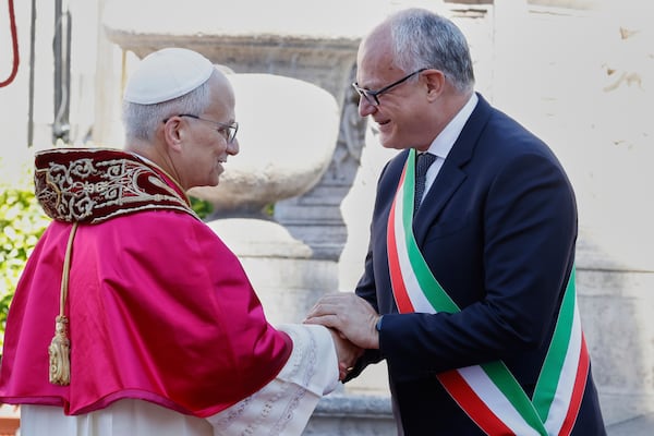 Pope Leo XIV is greeted by Rome's Mayor Roberto Gualtieri at the foot of Capitoline Hill, a symbolic gesture underscoring the pontiff's role as Bishop of Rome and his civic bond with the city, in Rome, Sunday, May 25, 2025. (AP Photo/Riccardo De Luca)