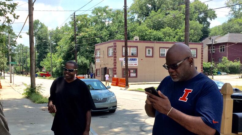 Greg Hightower (right) says he has renovated and sold eight homes in the Pittsburgh neighborhood. The locally infamous “Pink store” is in the background.