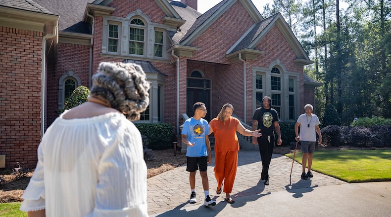 Sher’ree Kellogg (center) and her family stand outside their home, united in the face of uncertainty following the BioLab incident. With health concerns for both her 14-year-old son and elderly parents, the family has been staying close to home, waiting for more information and grappling with the potential long-term impacts. Tuesday, Oct. 8, 2024. (Olivia Bowdoin for the AJC).
