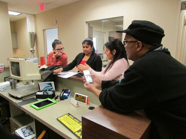 Helping set up the new Assistive Technology Lab at Cobb Senior Services are (from left) Tara Brewer (program specialist), Jobcy Alexander (nutrition program coordinator), Dawn Hedley (Life University intern) and Jack Thompson (nutrition program leader). Pictured are some of the mid- to high-tech items that can be used at home or at work. These include: a low-vision reader (looks like a computer) that magnifies text; a Chattervox that amplifies your voice so you can speak loudly; an iPad with a Good Grips case that makes it easier to hold; a cellphone flasher that rings loudly and flashes lights when your phone rings; a Reminder Rosie alarm clock that reminds you about your medication; a low-vision keyboard. CONTRIBUTED BY COBB SENIOR SERVICES