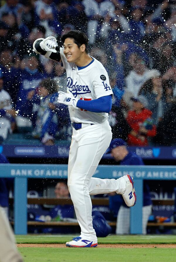 Los Angeles Dodgers' Shohei Ohtani is congratulated after a walk-off home run against the Atlanta Braves during the ninth inning of a baseball game Wednesday, April 2, 2025, in Los Angeles. (AP Photo/Kevork Djansezian)