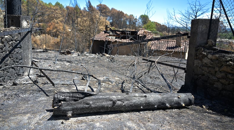 A gate and villa are burned after wildfires in Cotignac, France, Thursday, Aug. 6, 2026, as drought conditions worsen following a heatwave and water shortages across much of France. (AP Photo/Philippe Magoni)