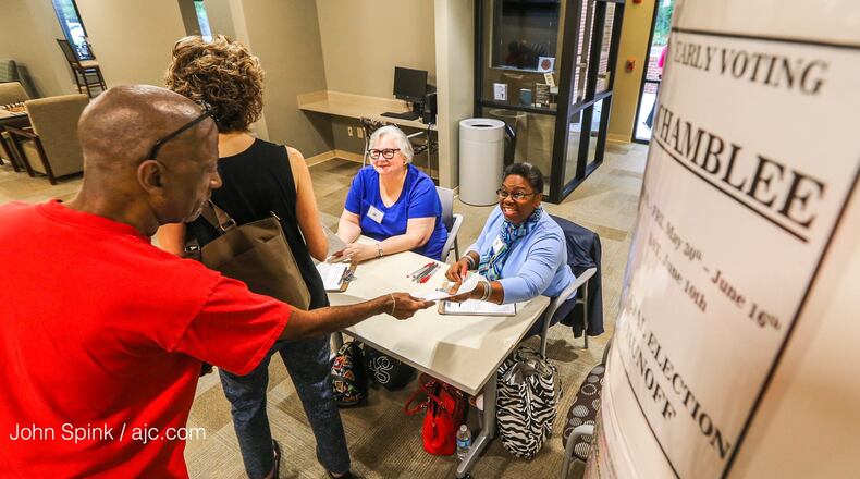 Gary Peeler (left to right) and Roberta Goldbaugh prepare to vote early in the Georgia 6th District runoff as poll workers Nancy Love and Esther Wilder check their papers at the DeKalb senior community center in Chamblee on May 30, 2017.