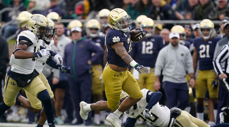 Notre Dame's Kyren Williams (23) runs past Georgia Tech's Miles Brooks (20) during the first half of an NCAA college football game, Saturday, Nov. 20, 2021, in South Bend, Ind. (AP Photo/Darron Cummings)