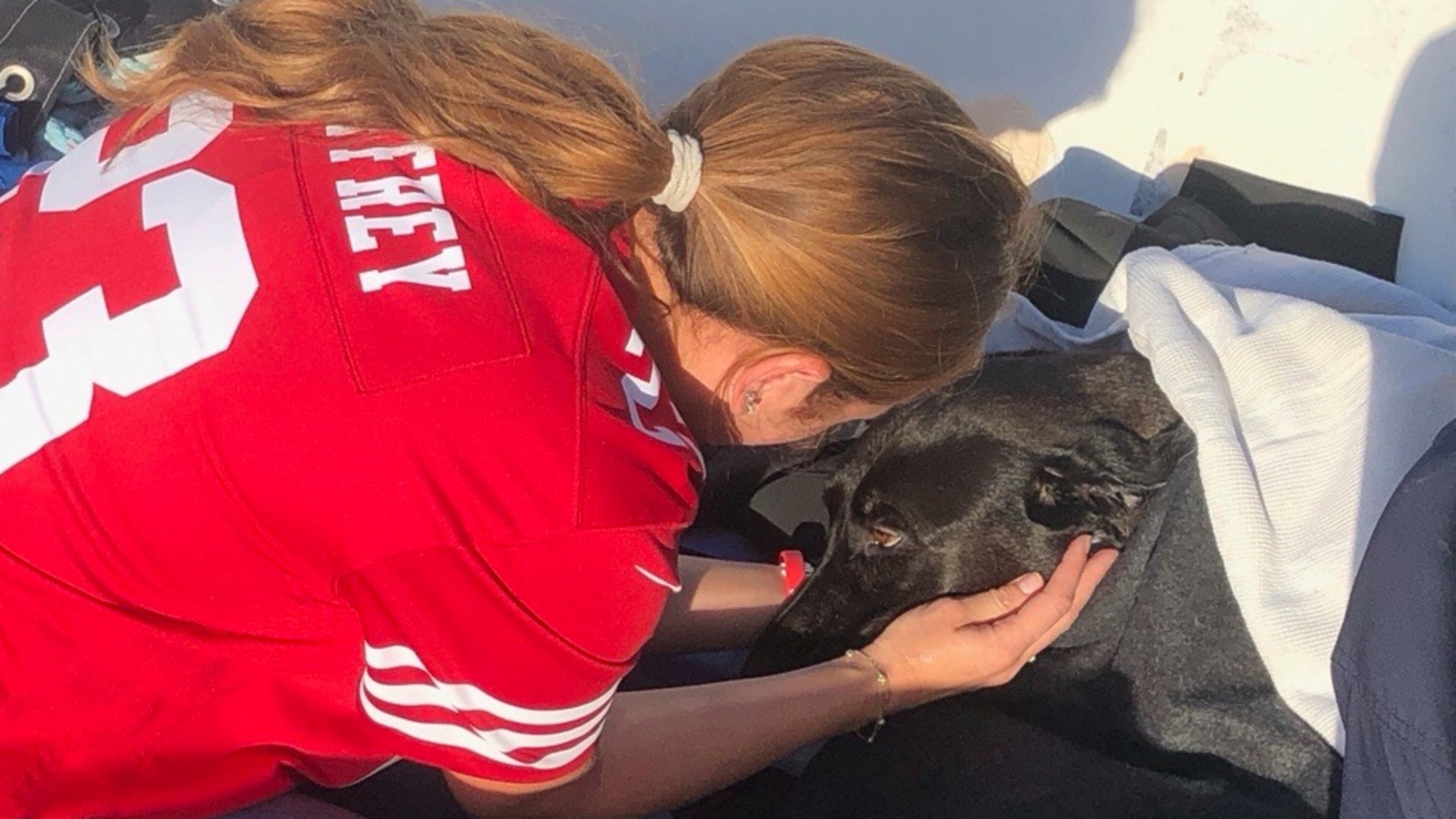 This photo released by San Diego Fire-Rescue shows owner Alexis reuniting with Sadie, a black Labrador retriever-mix, after Sadie was rescued from the water near Mission Beach, San Diego, Nov. 23, 2025. (San Diego Fire-Rescue via AP)
