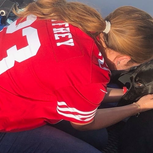 This photo released by San Diego Fire-Rescue shows owner Alexis reuniting with Sadie, a black Labrador retriever-mix, after Sadie was rescued from the water near Mission Beach, San Diego, Nov. 23, 2025. (San Diego Fire-Rescue via AP)