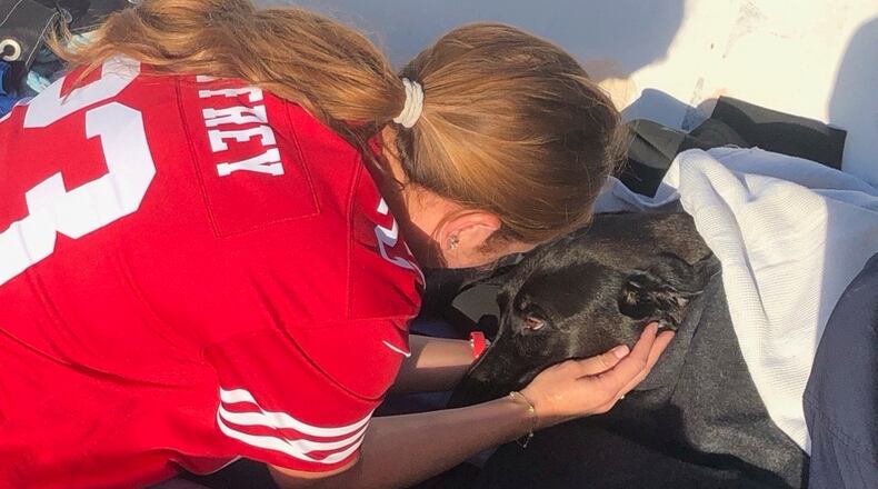 This photo released by San Diego Fire-Rescue shows owner Alexis reuniting with Sadie, a black Labrador retriever-mix, after Sadie was rescued from the water near Mission Beach, San Diego, Nov. 23, 2025. (San Diego Fire-Rescue via AP)