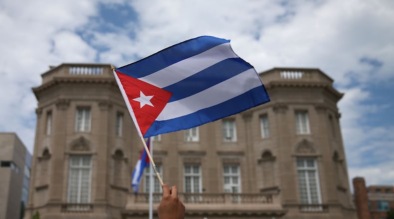 WASHINGTON, DC - JULY 20: A supporter waves a Cuban flag in front of the country's embassy after it re-opened for the first time in 54 years July 20, 2015 in Washington, DC. The embassy was closed in 1961 when U.S. President Dwight Eisenhower severed diplomatic ties with the island nation after Fidel Castro took power in a Communist revolution. (Photo by Mark Wilson/Getty Images)