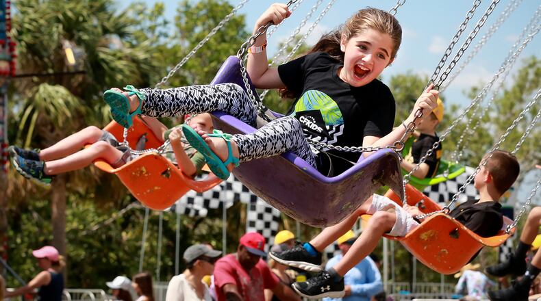 Children enjoy the Swinger ride at the North Palm Beach Heritage Day Festival in Anchorage Park Saturday, April 7, 2018. Following a Parade featuring bands, civic groups, clubs and organizations from the area, the Festival at Anchorage Park featured a business expo, carnival rides, food and drinks,
games, musical entertainment, a cornhole tournament, and more. (Bruce R. Bennett / The Palm Beach Post)
