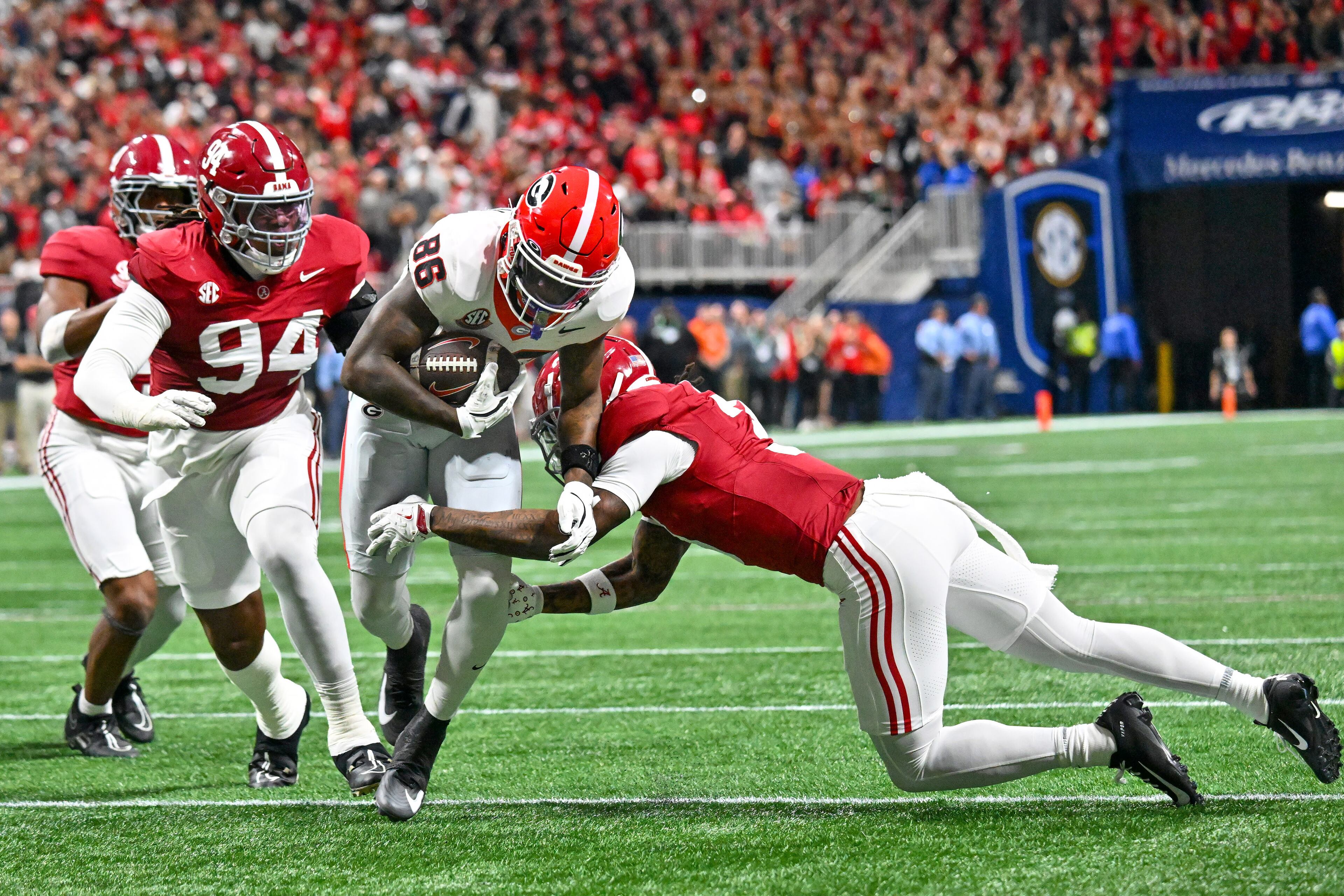 Georgia wide receiver Dillon Bell (86) is pursued by Alabama defensive lineman Edric Hill (94) during the first quarter of the SEC Championship game at Mercedes-Benz Stadium, Saturday, Dec. 6, 2025, in Atlanta. (Hyosub Shin / AJC)