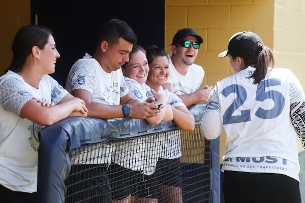 Players laugh together in the dugout during the first day of their attempt to break the world record for the longest kickball game.