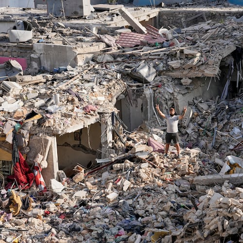 A man who returns to his village following the announcement of an initial ceasefire agreement between the United States and Iran, flashes victory sign as he stands on the rubble of his destroyed house in Nabatiyeh town, southern Lebanon, Tuesday, June 16, 2026. (AP Photo/Hussein Malla)