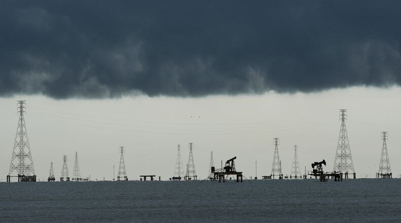 Clouds form over pumpjacks and power transmission towers on Lake Maracaibo in Cabimas, Venezuela, Tuesday, Sept. 1, 2026. (AP Photo/Ariana Cubillos)