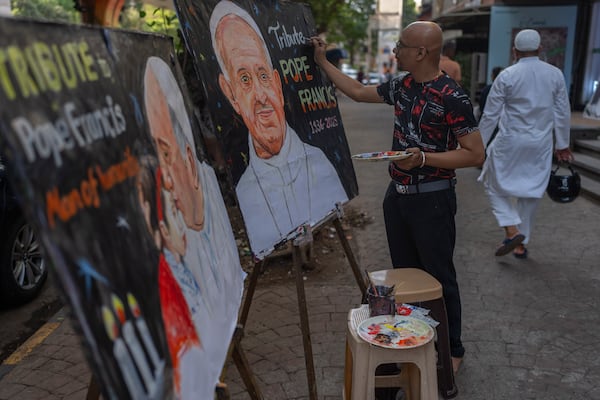 An Indian artist Sagar Kambli makes a painting of Pope Francis as a mark of tribute on a sidewalk in Mumbai, India, Monday, April 21, 2025. (AP Photo/Rafiq Maqbool)