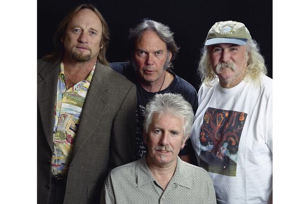 FILE - Musicians Stephen Stills, left, Neil Young, background center, Graham Nash, seated, and David Crosby pose for a photo at the Pierre Hotel, Oct. 13, 1999, in New York. (AP Photo/Jim Cooper, File)