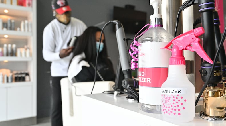 January 26, 2021 Atlanta - Brandon Newton, hairstylist, styles his customer Laureynn Elie's hair at Blo Blow Dry Bar in Buckhead on Tuesday, January 26, 2021. The pandemic has been hard on small businesses and hard on companies that rely on in-person transactions, and hardest on those that are both. (Hyosub Shin / Hyosub.Shin@ajc.com)