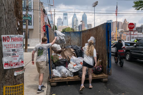 Southwest Center City residents dispose of their garbage at a designated trash collection site on Catharine Street and South 18th Street in Philadelphia, on Tuesday, July 1, 2025. (Kaiden J. Yu/The Philadelphia Inquirer via AP)