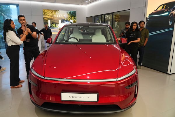 Media personnel look at the Tesla's Model Y car at the newly opened India's first Tesla showroom in Mumbai, India, Tuesday, July 15, 2025. (AP Photo/Rafiq Maqbool)