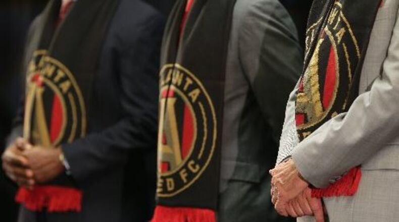 August 4, 2015 Decatur: Decide DeKalb President Ray Gilley, from left, DeKalb Interim CEO Lee May and Atlanta United FC owner Arthur Blank sport their team scarves during an August 4 announcement that Atlanta United FC would locate their headquarters and practice facility in DeKalb Couny. (Ben Gray / bgray@ajc.com)