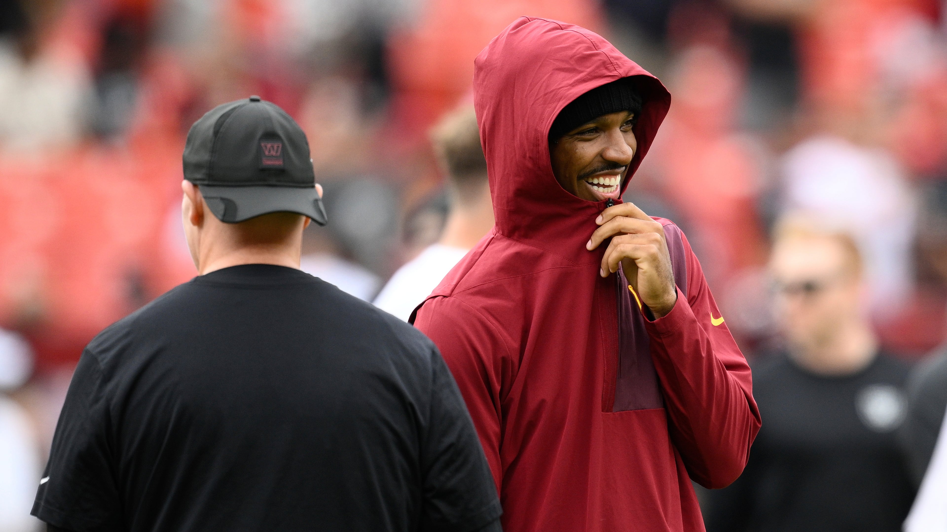 Washington Commanders quarterback Jayden Daniels, right, watches during warm ups before an NFL football game against the Las Vegas Raiders, Sunday, Sept. 21, 2025, in Landover, Md. (AP Photo/Nick Wass)