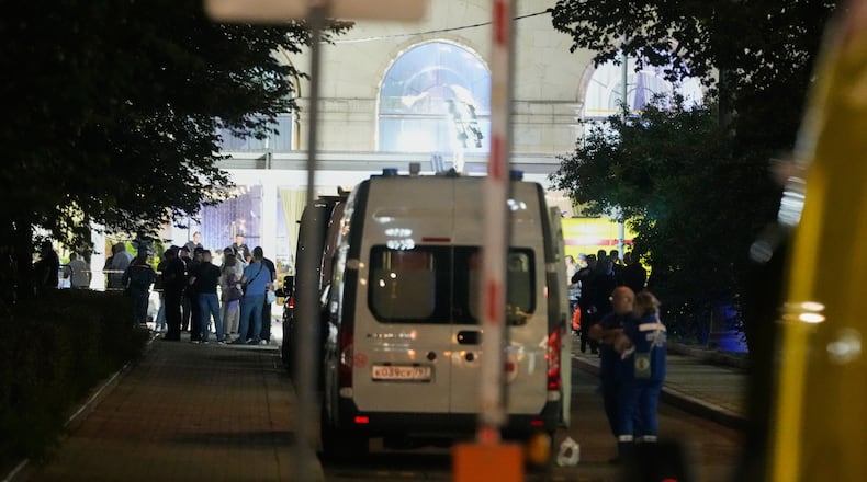 Ambulances and special services vehicles are parked near the site where an improvised explosive device detonated at a restaurant in central Moscow, Saturday, Aug. 1, 2026. (AP Photo/Pavel Bednyakov)