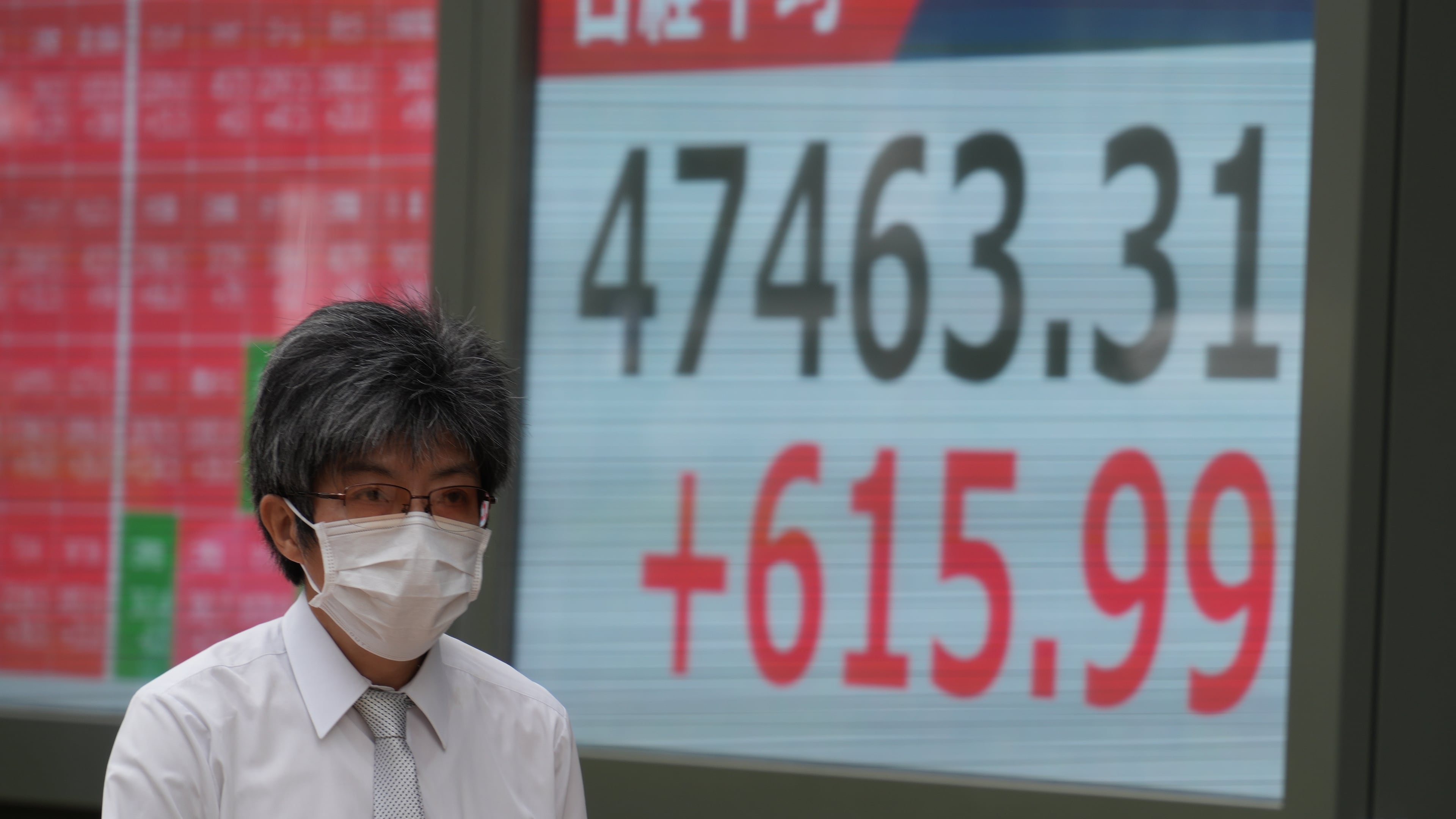 A person walks in front of an electronic stock board showing Japan's Nikkei index at a securities firm Wednesday, Oct. 15, 2025, in Tokyo. (AP Photo/Eugene Hoshiko)