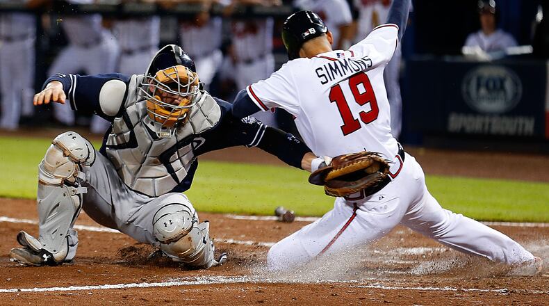 Shortstop Andrelton Simmons #19 of the Atlanta Braves slides behind catcher Derek Norris #3 of the San Diego Padres in the sixth inning to score the tying run during the game at Turner Field on June 9, 2015 in Atlanta, Georgia. (Photo by Mike Zarrilli/Getty Images)