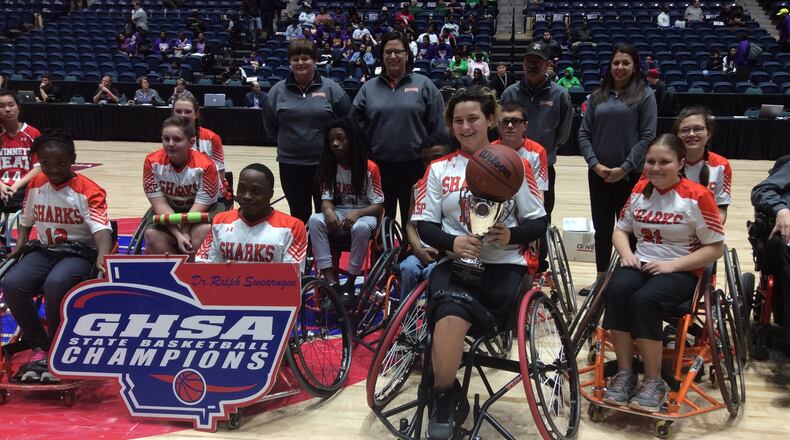 Senior Jordan Kozloski holds the trophy after scoring 19 points to lead the Houston County Sharks to a 39-17 victory over the Gwinnett Heat in the wheelchair basketball state championship game Friday at the Macon Coliseum.