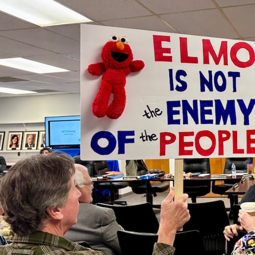 An audience member holds a sign at a meeting of the Alabama Educational Television Commission on Tuesday, Nov. 18, 2025, in Birmingham, Ala. (AP Photo/Kim Chandler)