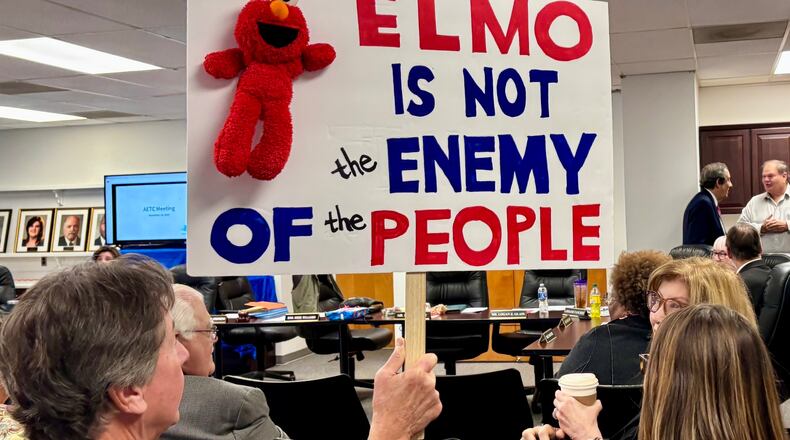 An audience member holds a sign at a meeting of the Alabama Educational Television Commission on Tuesday, Nov. 18, 2025, in Birmingham, Ala. (AP Photo/Kim Chandler)