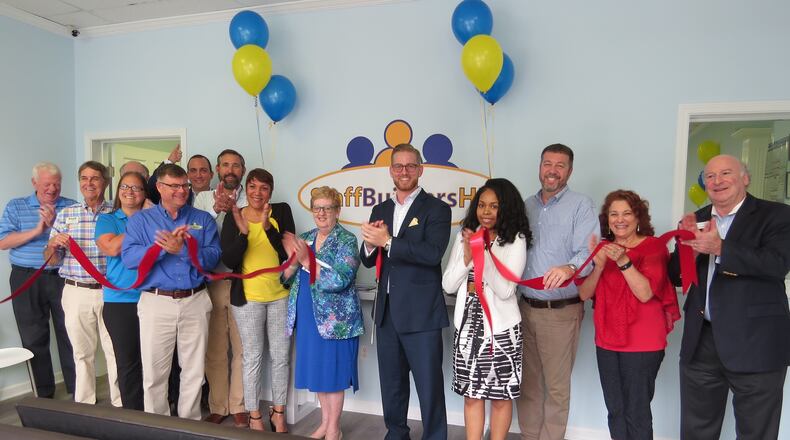 Councilmember Lorri Christopher (center in blue dress), welcomed Austin Ashworth (in dark suit to the right of Christopher) and his staffing company to Peachtree Corners. Members of the Southwest Gwinnett Chamber were on hand to help celebrate the occasion. (Courtesy City of Peachtree Corners