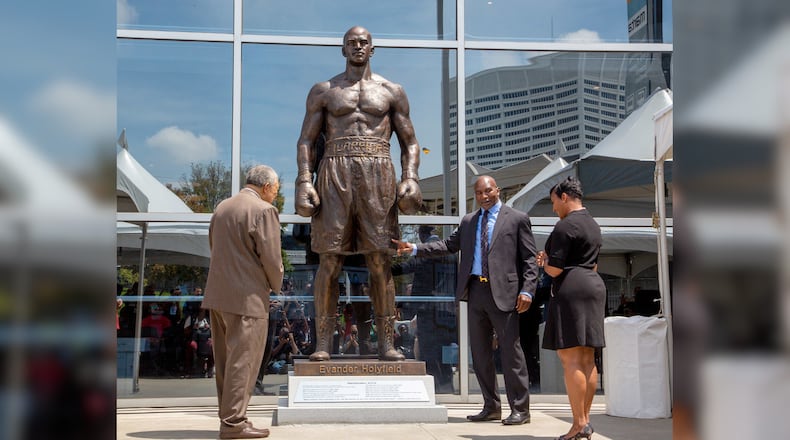 Evander Holyfield, Atlanta Keisha Lance Bottoms (right), and Fulton County Board of Commissioners Chairman Robb Pitts (left) look over a bronze statue in Holyfield's likeness at State Farm Arena on Friday, June 25. STEVE SCHAEFER FOR THE ATLANTA JOURNAL-CONSTITUTION
