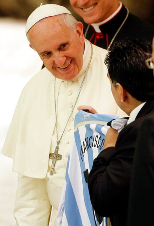 FILE - Diego Armando Maradona presents Pope Francis with an Argentine national soccer team jersey bearing the name Francisco on it, in the Paul VI hall at the Vatican, Monday, Sept. 1, 2014 ahead of an interreligious match for peace. (AP Photo/Gregorio Borgia, File)