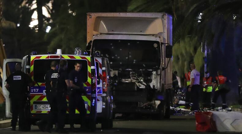 Police officers and rescued workers stand near a van that ploughed into a crowd leaving a fireworks display in the French Riviera town of Nice on July 14, 2016. The mayor of the French city of Nice said dozens of people were likely killed after a van rammed into a crowd marking Bastille Day in the French Riviera resort today and urged residents to stay indoors. / AFP / VALERY HACHE (Photo credit should read VALERY HACHE/AFP/Getty Images)