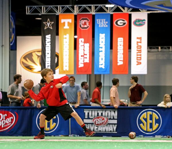 Georgia fan Rhett Howard, 7, of Snellville, attempts a pass during a passing challenge at the SEC FanFare at the Georgia World Congress Center on Dec. 6, 2013. Jason Getz / AJC