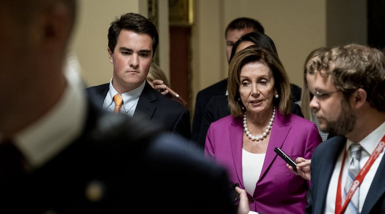 Speaker Nancy Pelosi, D-Cal., speaks to reporters as she makes her way to the U.S. House chamber to vote on a resolution denouncing comments by President Trump targeting four progressive Democratic congresswomen of color. Pete Marovich/Getty Images
