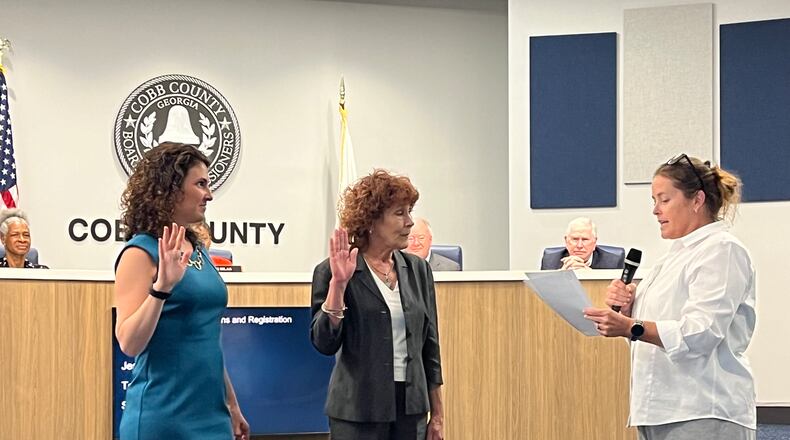 Stacy Efrat (left) and Debbie Fisher (center) are sworn in to serve on the Cobb County Board of Elections by Chief Judge Kelli Wolk (right) on Thursday, June 29, 2023. (Taylor Croft/taylor.croft@ajc..com)