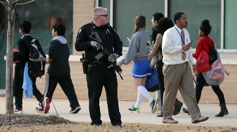 February 18, 2014 Chamblee: A police officer keeps his eye on students as they are dismissed from Chamblee Charter High School on Tuesday afternoon February 18, 2014 after police arrested a suspended student who was across the street from the school with two pistols. Police said the student stole the guns while burglarizing a neighborhood house earlier in the day and may have been trying to sell the guns. He also had several duffle bags with long guns stashed near the schools' football stadium. BEN GRAY / BGRAY@AJC.COM An officer keeps his eye on students as they are dismissed from Chamblee Charter High School in February after police arrested a suspended student across the street from the school with two pistols. Ben Gray, bgray@ajc.com
