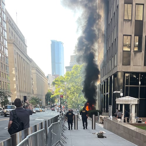 This photo provided by Robert Sullivan shows black smoke and flames in front of 26 Federal Plaza in lower Manhattan, Monday, July 20, 2026, in New York. (Robert Sullivan via AP)