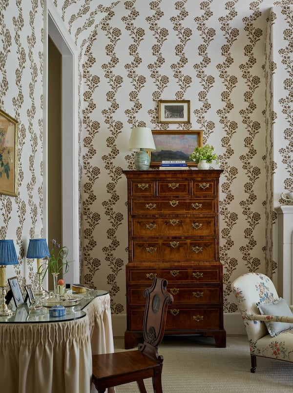 Wallpaper featuring brown flowers and an antique chest of drawers ground this bedroom from interior designer Lauren E. Lowe of Lauren Elaine Interiors in warmth and strikes a balance between masculine and feminine. (Courtesy of Emily Followill)