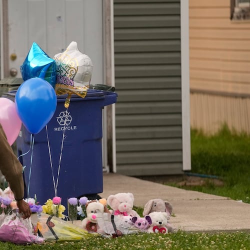 A person leaves a gift at a makeshift memorial on the front lawn of the home where children were killed during a mass shooting the day before in Shreveport, La., Monday, April 20, 2026. (AP Photo/Gerald Herbert)