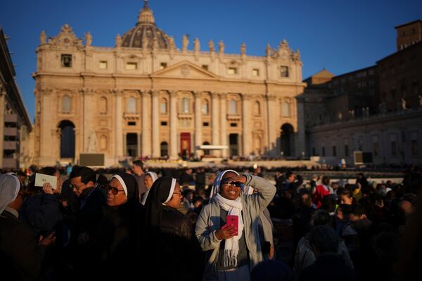 A nun smiles as she waits ahead of the funeral of Pope Francis in St. Peter's Square at the Vatican, Saturday, April 26, 2025. (AP Photo/Emilio Morenatti)
