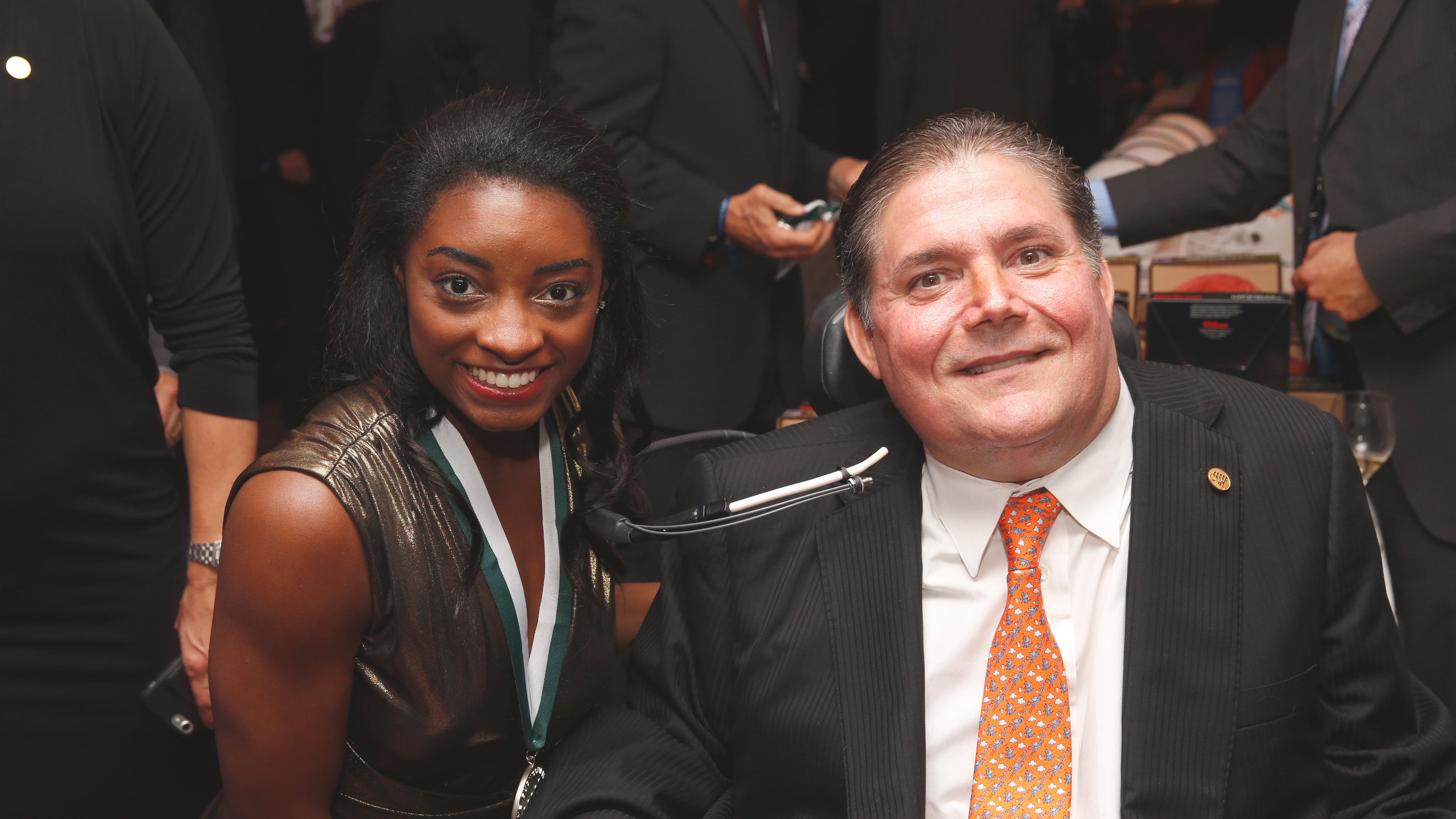 In this photo released by The Buoniconti Fund to Cure Paralysis, Olympic gold medal winning gymnast Simone Biles, left, poses with The Buoniconti Fund to Cure Paralysis President Marc Buoniconti at the 2018 Great Sports Legends Dinner, Sept. 24, 2018, to benefit the fund in New York. (The Buoniconti Fund to Cure Paralysis via AP)